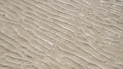 Natural sand pattern on flat sandy beach during low tide.