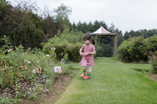 young girl taking photo in the summer garden morning