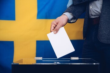 Election in Sweden - voting at the ballot box. Flag of Sweden on background.