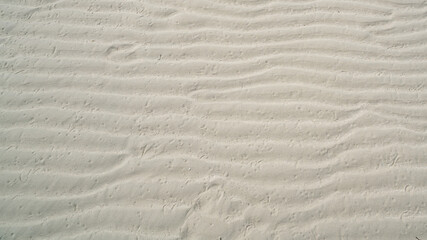 Fototapeta na wymiar Natural sand pattern on flat sandy beach during low tide.