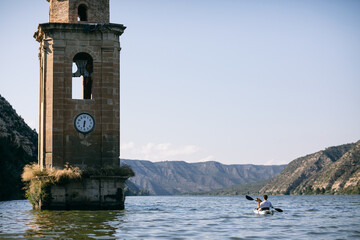 Anonymous traveler riding boat near tower