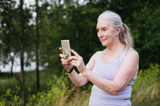 Senior woman takes selfies with a smartphone.