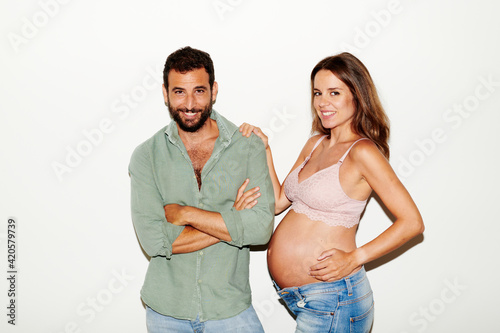 Modern diverse couple expecting baby looking at camera