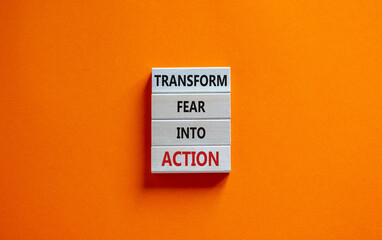 Transform fear into action symbol. Businessman holds wooden blocks with words 'Transform fear into action'. Beautiful orange background, copy space. Business, transform fear into action concept.