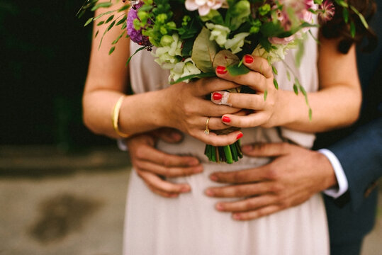 bride and groom holding a wonderful pink bouquet