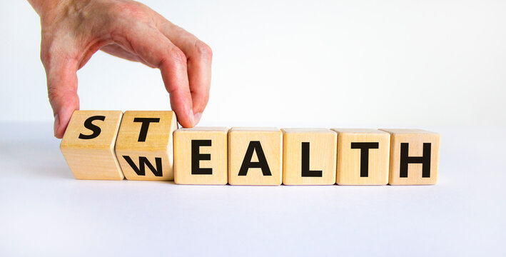 Stealth Wealth Symbol. Businessman Turns Wooden Cubes And Changes The Word 'wealth' To 'stealth'. Beautiful White Background. Business, Stealth Wealth Concept. Copy Space.