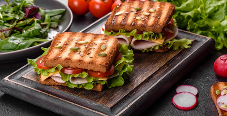 Delicious sandwich with crisp toast, ham, lettuce and tomatoes