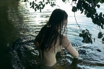 a girl with her hair down goes into the water