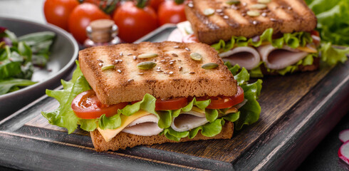 Delicious sandwich with crisp toast, ham, lettuce and tomatoes