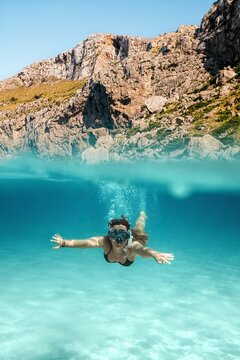 Woman snorkeling near rocky coast