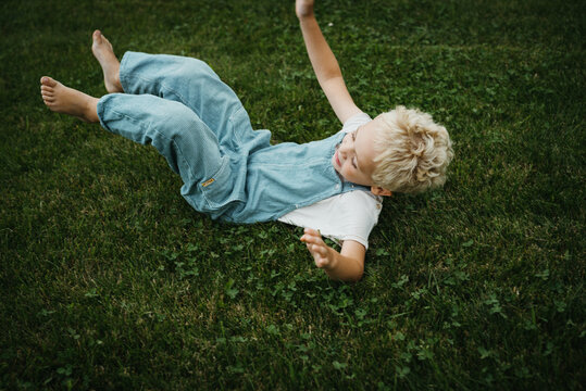 little boy rolling over in the garden