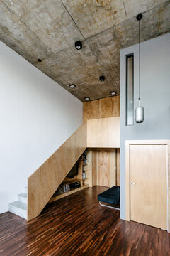 Staircase in a loft painted in gray with concrete ceiling and wood floor