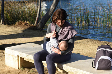 a mother dressed in sportswear breastfeeding her child