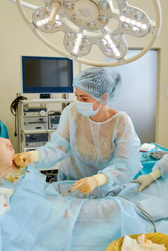 female doctor performs breast augmentation surgery for a woman