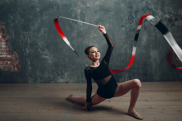 Young girl professional gymnast woman rhythmic gymnastics with ribbon at studio