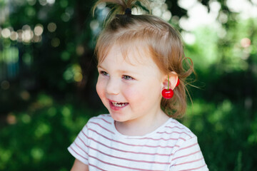 Little girl playing with cherries