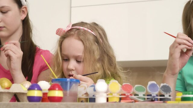 The girl shows her friends an egg that she painted red. Easter holiday. 4k video.