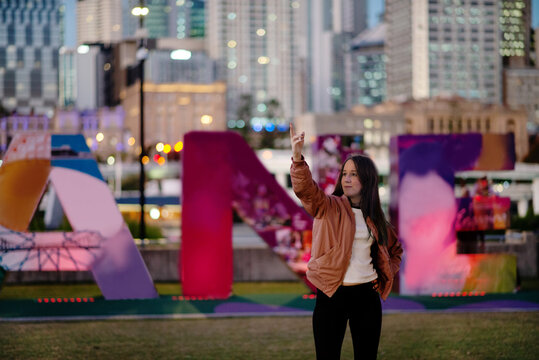 girl posing in front of Brisbane sign