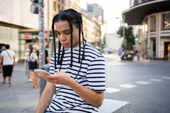 Teenage Boy Texting On The Streets.