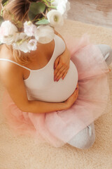 Pregnant woman stay in the room and look at the belly