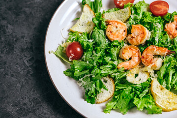 Fresh salad with shrimp, tomatoes and parmesan cheese in a plate, close-up. Healthy food