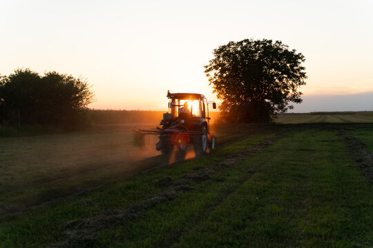 Tractor working on the field at sunset