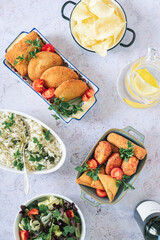 Traditional Portuguese fried snacks: cod fish cakes, rissóis, croquettes and samosas with parsley rice, salad, water and wine.