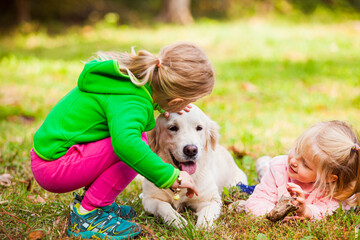 Obraz premium Two girls spend time with their obedient dog