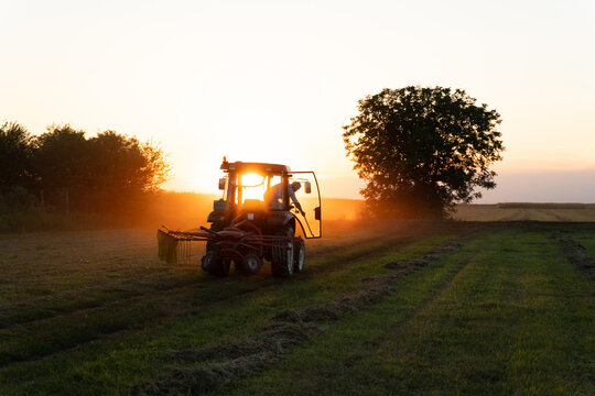 Tractor working on the field at sunset