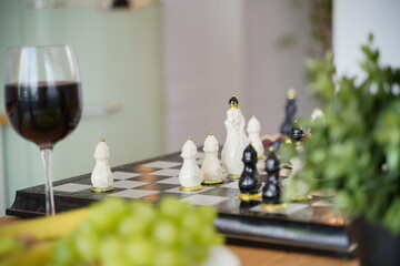 Close up of beautiful chess on table in room. Selective focus of porcelain chess pieces on chessboard.