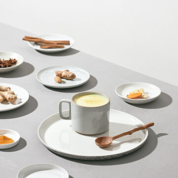 Turmeric detox tea and ingredients on a gray cement background.