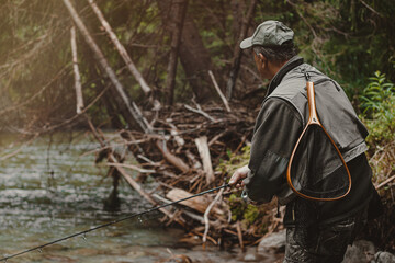 Fototapeta na wymiar Fisherman walking through dark forest