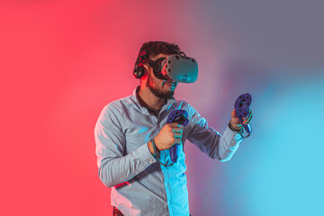 Young man using the virtual reality glasses and two gamepad © oksix