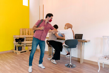 Coworkers Using Face Mask Elbow Bumping