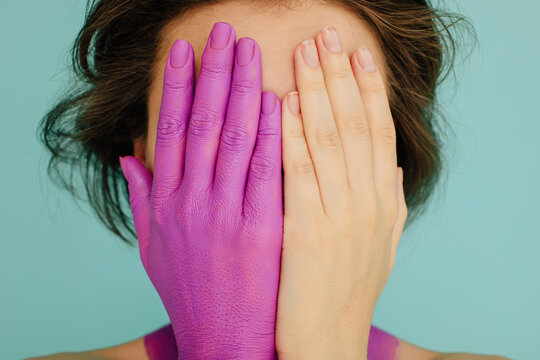 Model hiding her face with colorful hands