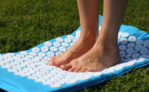 Crop person standing on massage mat