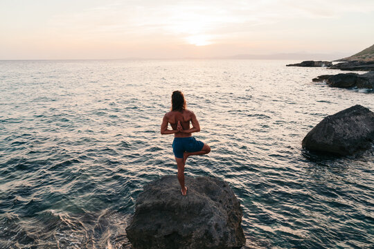 Man doing yoga at the sea