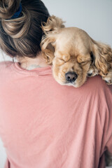 Young woman hugs her dog. The dog lies on the shoulder at a young woman