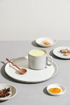 Turmeric detox tea and ingredients on a gray cement background.