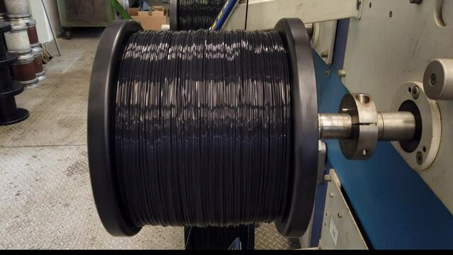 Bobbin winding machine. Detail from a spool with plastic filament