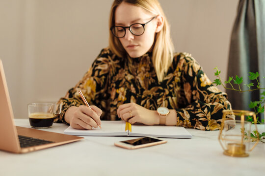 Young Woman Taking Notes At Home