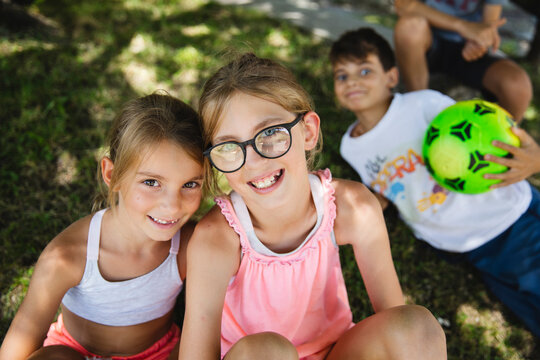 Portrait of two little girlfriends with intruder in the background