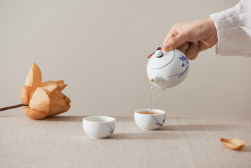 person pours tea into cup isolated on white for your text