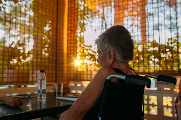 Elderly woman sitting outdoor at sunset