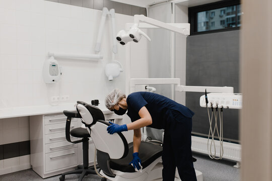 Dentist assistant disinfect chair in office