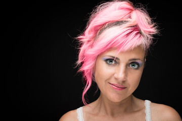 Caucasian girl model with pink hair and blue, green eyes and black background