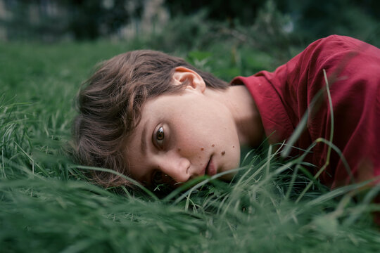 Thoughtful woman lying on grass