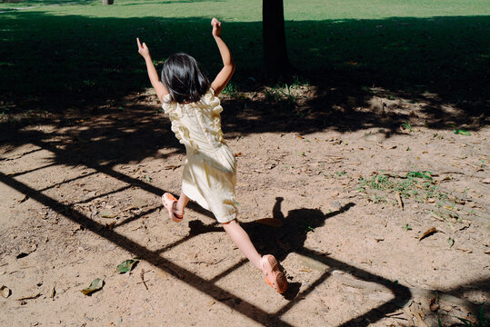Little girl jumping in the shadow