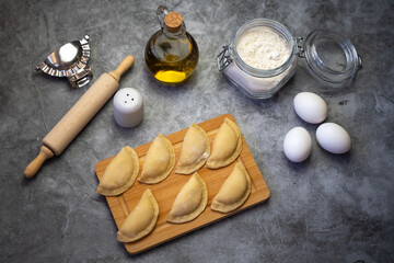 Raw dumplings (vareniki) with potato made at home. Traditional Russian dumplings on a wooden board.