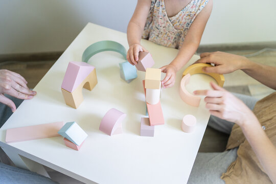 Family playing together with wooden toys at home